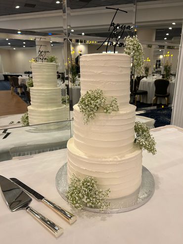 3 tier white buttercream cake with baby's breath and acrylic topper. 