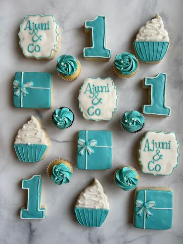 Teal and white decorated sugar cookies in a Tiffany & Co theme, with mini cupcakes to match. 