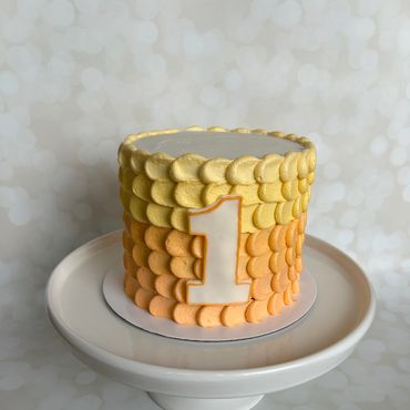 Orange and yellow ombre buttercream smash cake with a fondant 1 on the front. 