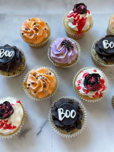 Halloween cupcakes with flowers, a spider, and Boo. 