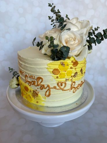 A 'what will baby bee' theme buttercream cake with fresh flowers. 