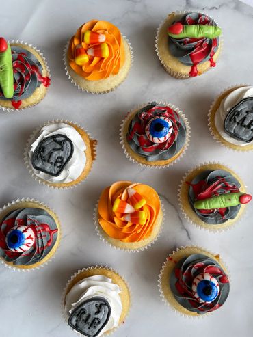 Halloween cupcakes decorated with candy corn, fondant fingers, and eyeballs. 