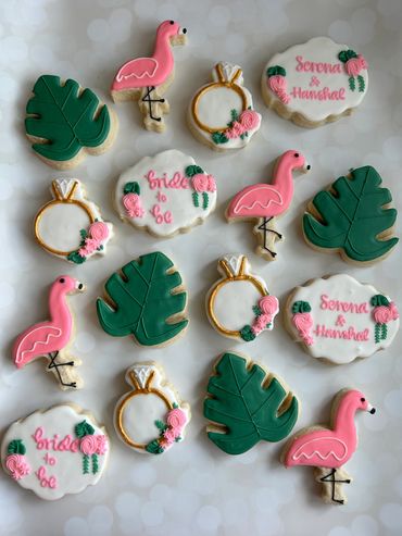 Tropical theme sugar cookies for an engagement party with flamingos and monstera leaves. 