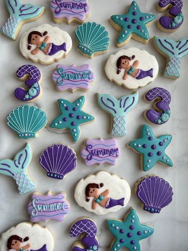 Mermaid theme cookies with a starfish, tail, and seashell. 
