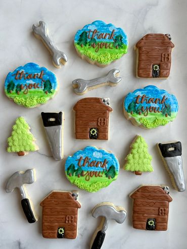Decorative cookies shaped like tools, houses, trees, and thank yous. 