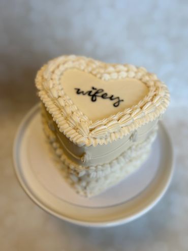 A white vintage heart with piping. 