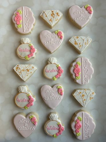Pink and gold theme engagement cookies for two brides with floral details. 