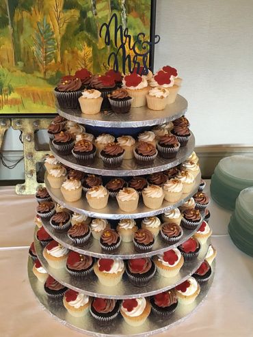 Tower of mini and regular size cupcakes with fondant flower accents. 