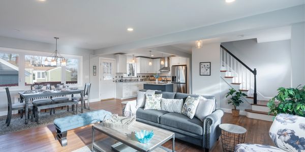 Bright open living room with modern furniture and kitchen.