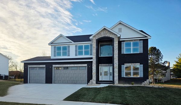 Modern two-story house with black and white exterior and a three-car garage.