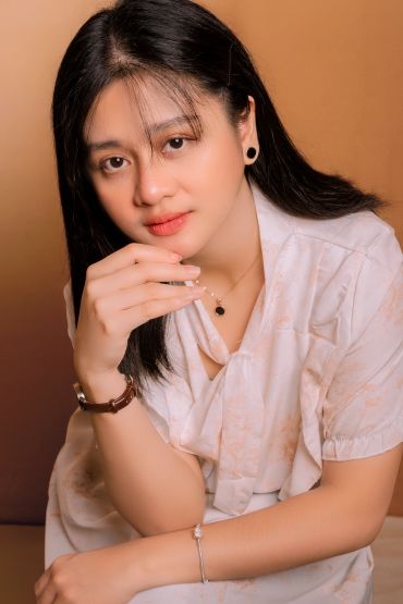Portrait of a young woman with black hair and subtle makeup.