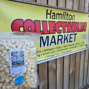 A bag of kettle corn in front of a collectables market sign.
