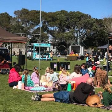 People relaxing at an outdoor event on a sunny day.