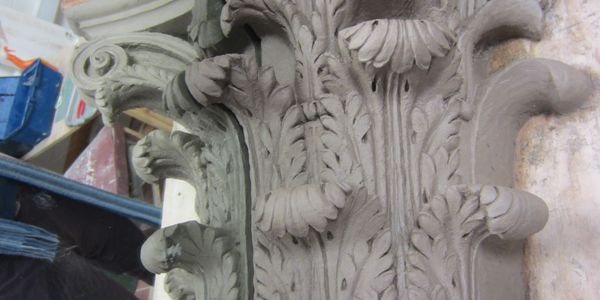 Close-up of an intricately carved stone architectural element with leaf motifs.