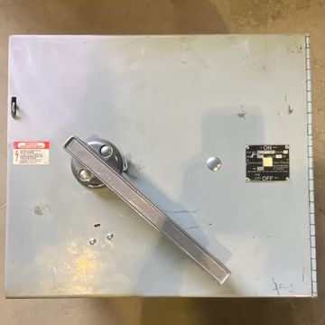 Gray electrical switch box with a large metal handle and labeled ON/OFF switch.