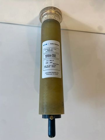 A cylindrical industrial filter with a label and a black valve at the bottom.