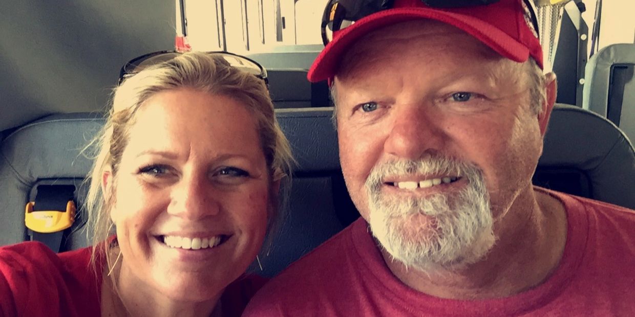 Smiling man and woman taking a selfie on a bus.