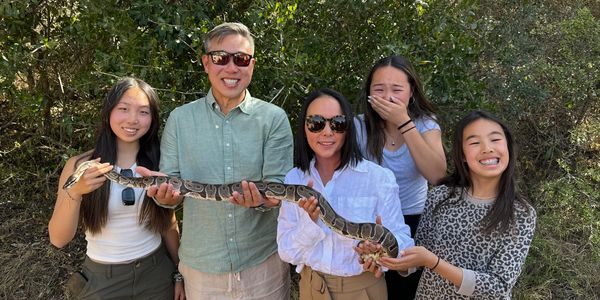 My family holding a large snake while on safari in South Africa with Adventures by Disney - Story Lim