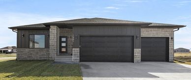 Modern house with double garage and large driveway.