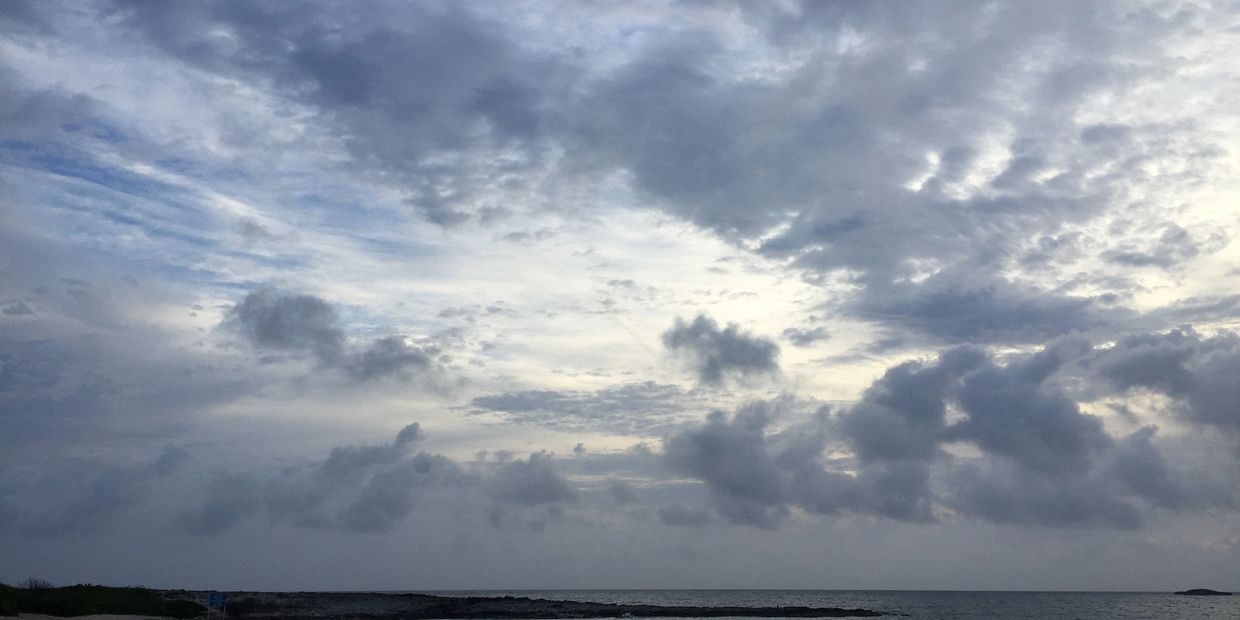 Cloudy sky over a calm sea.