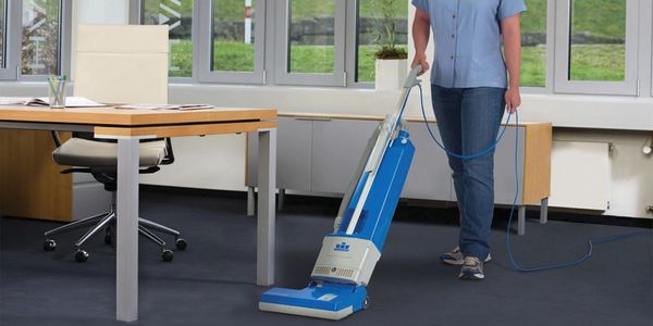 Technician vacuuming as part of Office Cleaning Service.
