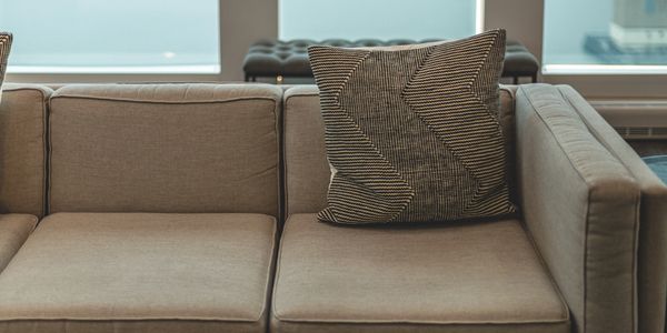 Freshly Cleaned Grey Couch with Patterned Pillow