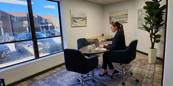 Woman working on laptop in a modern office.