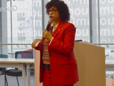 Person in red suit speaking with a microphone.