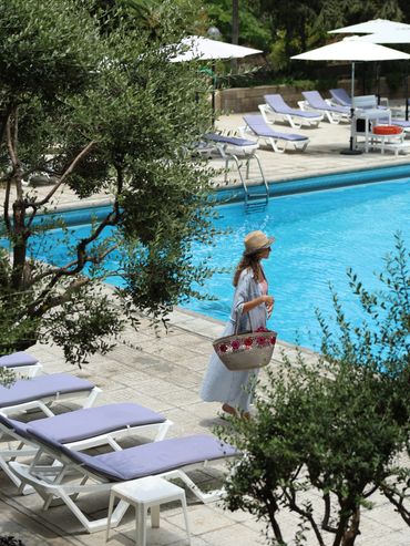 Outdoor swimming pool at St PAUL Resort in Tabarja, Lebanon, surrounded by sun loungers and Mediterranean gardens.