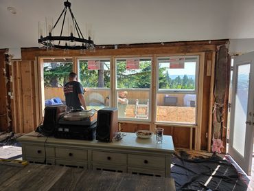Two men installing windows during home renovation.