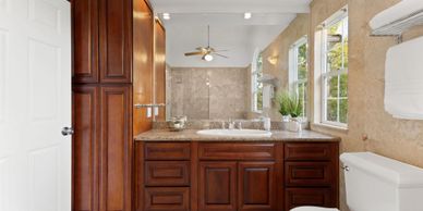 Elegant bathroom with wooden cabinetry and granite countertop.