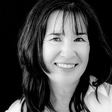 Smiling woman with medium-length hair in black and white photo.