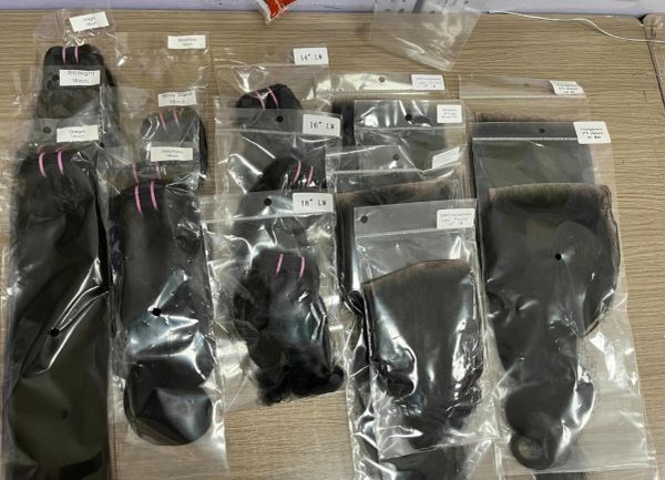 Various lengths of black hair extensions packaged in clear plastic bags.