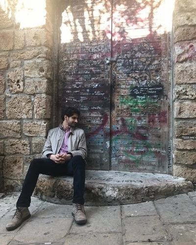 Nadi sitting next to a colorful door in Lebanon