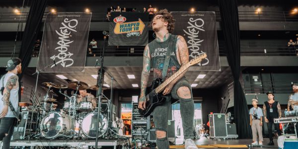 Band performing live on stage with electric guitar and drums.