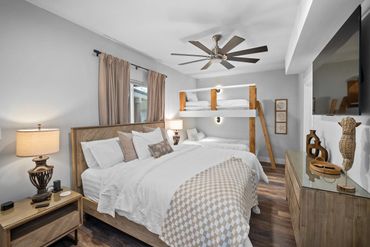 Cozy bedroom with a large bed, bunk bed, and modern rustic decor.