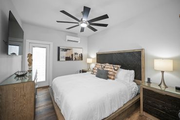 Modern bedroom with a large bed and ceiling fan.
