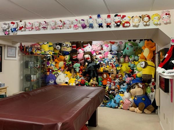 A room filled with various plush toys arranged on shelves and walls.
