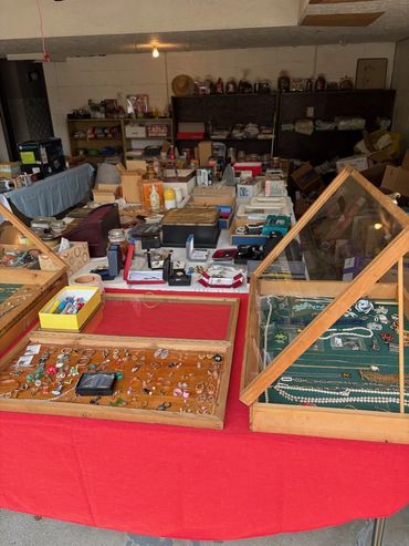 Indoor flea market with jewelry displays and various items.