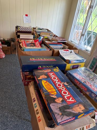 Table with various board games and books in boxes.