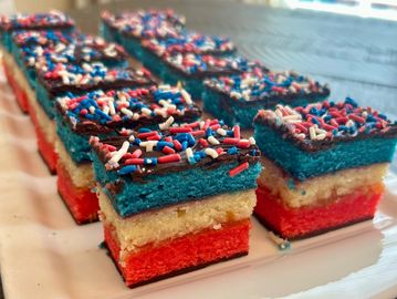 Layered red, white, and blue cake squares with sprinkles.