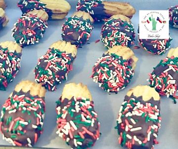 Chocolate-dipped treats with red, white, and green sprinkles arranged on a tray.