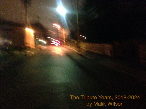 Blurry night street scene with glowing lights and text overlay.
