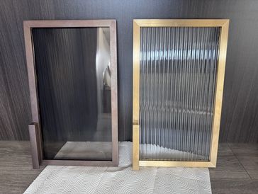 Two rectangular glass panels with brass cabinet door frames.