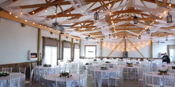 Rustic barn interior with old barn wood wainscoting and high open ceilings.
