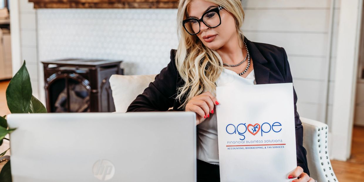 Businesswoman holding a sign for Agape Financial Business Solutions.