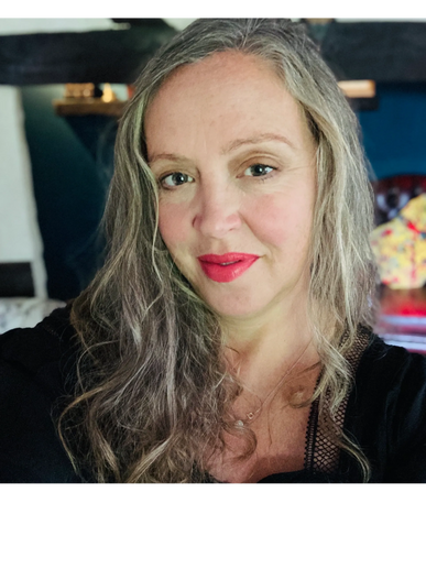 Close-up portrait of a woman with gray hair and bright lipstick smiling gently.