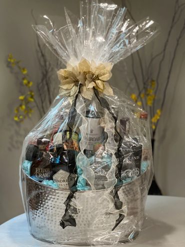 Gift basket wrapped in clear plastic with a decorative bow.