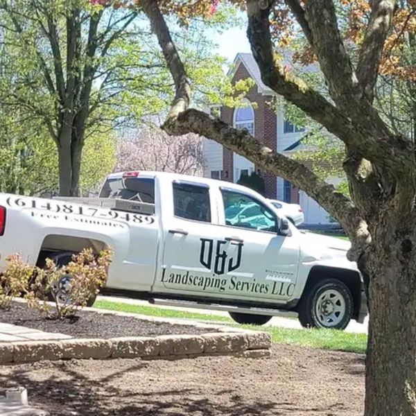 White landscaping service truck parked on a suburban street.