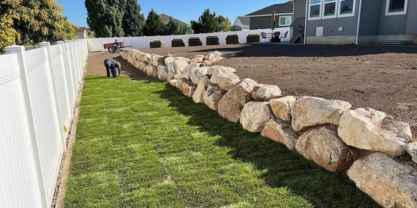 Rock wall with brand new sod being installed